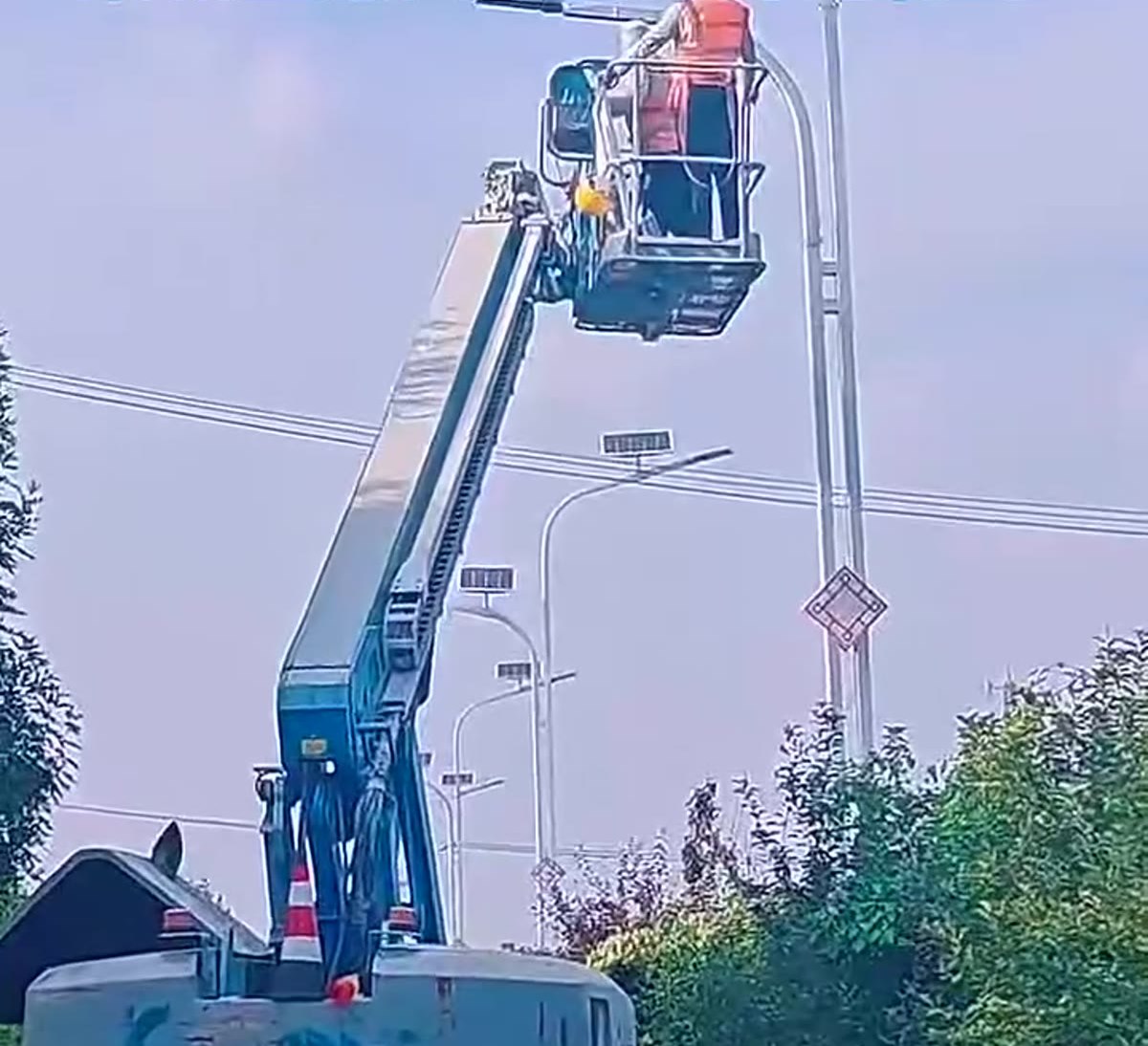 Technicians working on a solar street light head during installation